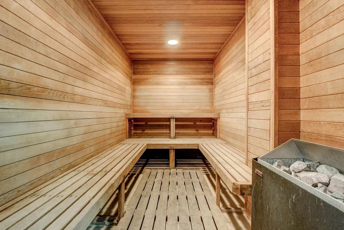 An inviting sauna with wooden benches and a heater, exuding warmth and calm. The soothing interior offers a private retreat for relaxation and rejuvenation after a day of adventure.