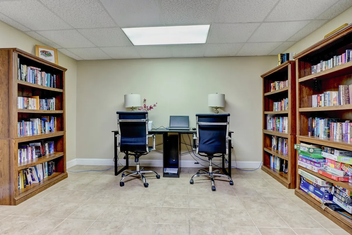 A productive, inviting workspace featuring bookshelves, desks, computers, and lamps, creating an environment suited to concentration and collaboration.